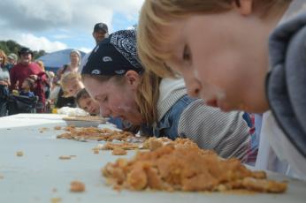 (Lorrie Ross• Clay County Progress) Daily pumpkin pie eating contests gather dozens of people to cheer on their favorite pie eaters. The competition sometimes gets fierce between siblings or friends eating pie side by side.