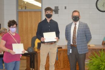Hayesville High School students Michelle Pegues and Brady Shook tied for first place in the youth logo design contest held by People of Clay CARE. The students' logos were com- bined into one logo for the coalition. School Superintendent Dale Cole presented the students with their certificates and awards from the prevention coalition.