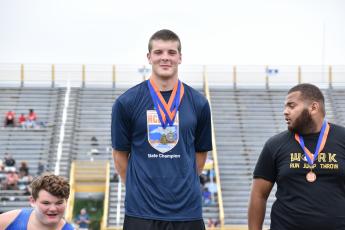 (Kevin Hensley • Graham Star) Jake McTaggart stands atop the podium with his gold medal for discus and silver medal for shot put.