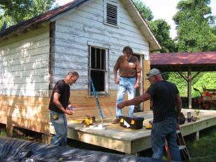 Tommy Davis of Woodhaven Construction, center, consults with carpenters Jeremiah Burch, left and David Collins, right, for replacing  damaged wood on the 1930s Hayesville Town Hall building as a classroom with porch added for outdoor presentations.