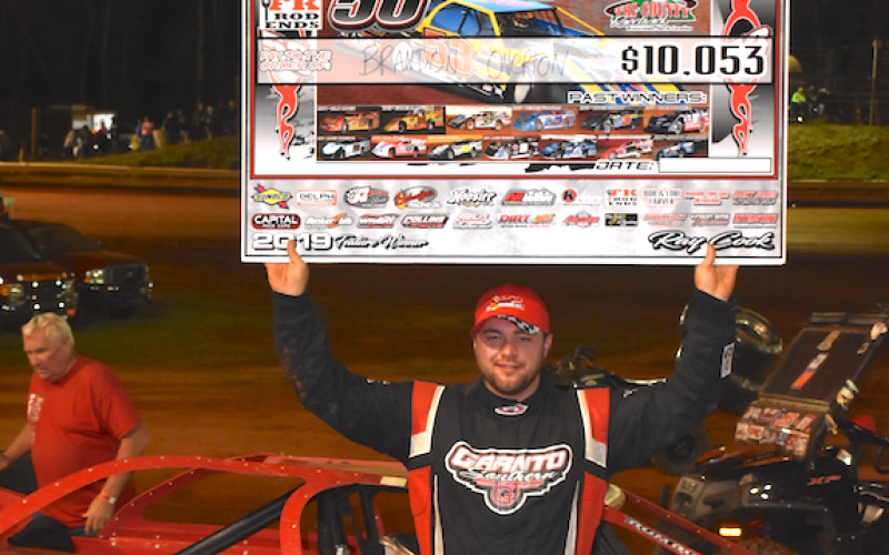 (Travis Dockery • Clay County Progress) “Big Sexy” Brandon Overton proudly shows of his reward for winning the 16th Tarheel 50 at Tri County Racetrack.