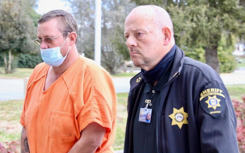 Charles Jason Matheson waived extradition to Georgia from Clay County and is being escorted to the Towns County Courthouse by Towns County Sheriff Kenneth Henderson. 