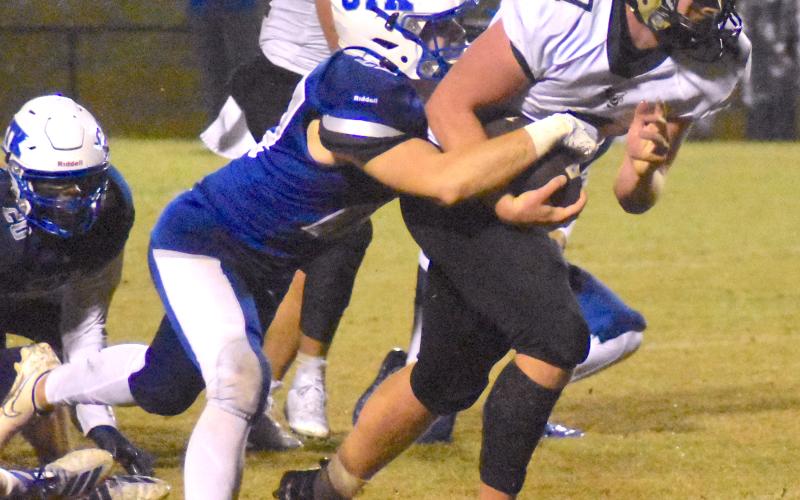 Gary Corsair • Clay County Progress Hayesville fullback Kyle Lunsford, No. 7, drags a Christ The King player upfield as guard Jeremy Graves, No. 51, looks for another Crusader to block.