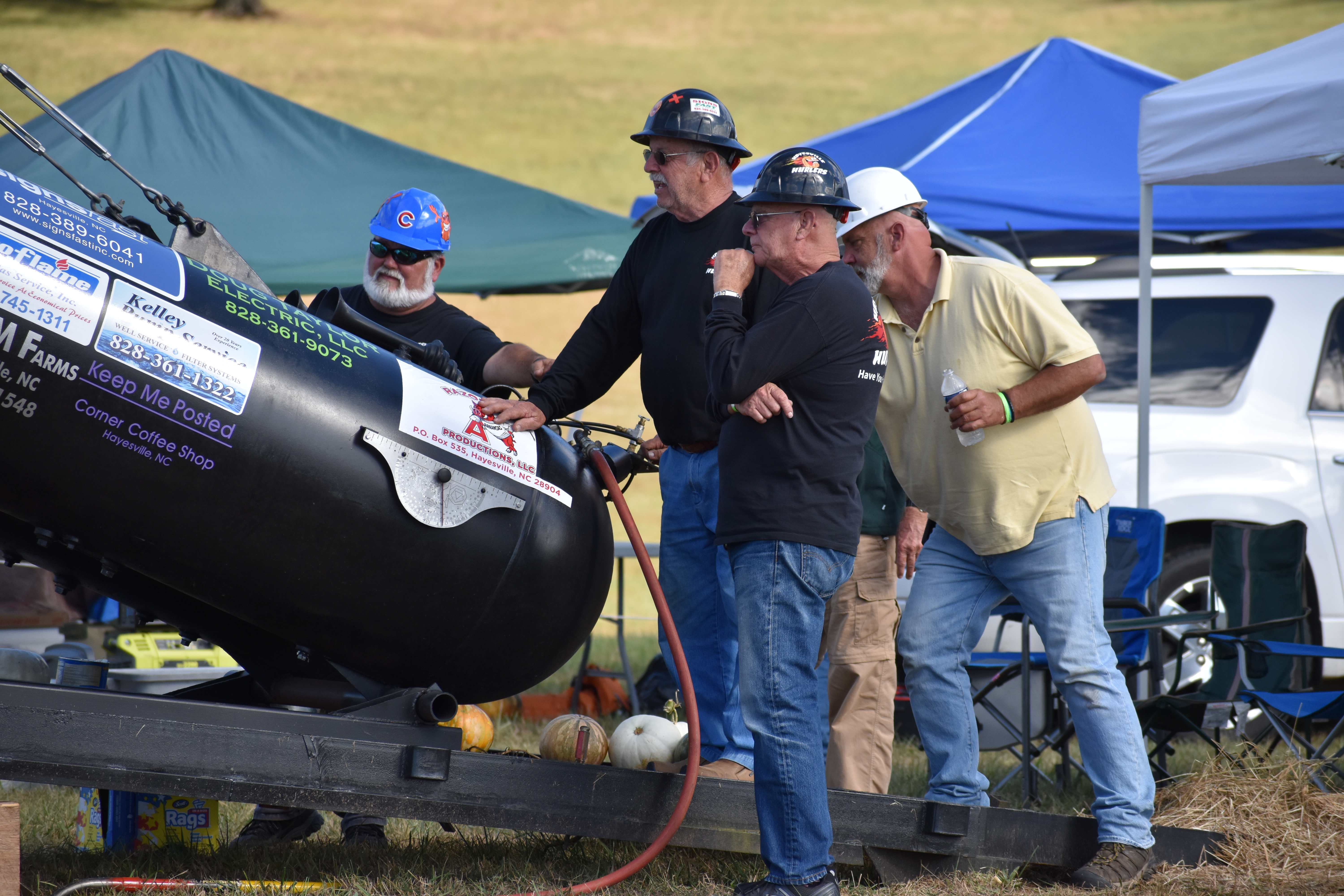 Members of the Hayesville Hurlers examine the cannon before the pumpkin launching.
