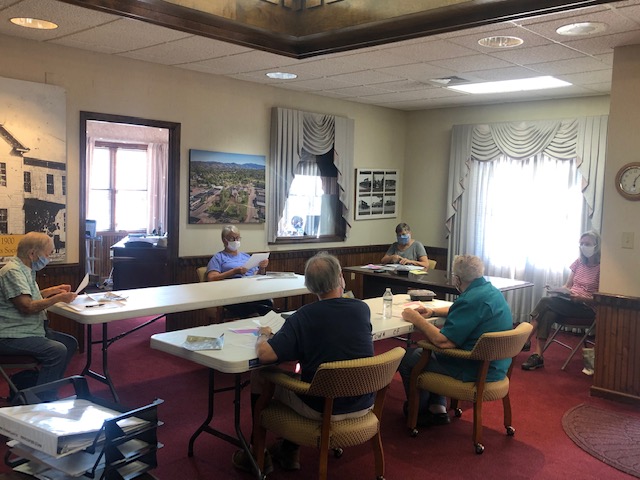 Lorrie Ross • Clay County Progress The Hayesville Planning and Zoning Board meets using COvid-19 precautions. Everyone must wear a mask and be seated at least six feet apart. Left to right clockwise: Patricia Schaaf, Sandy Mazza, Rachel Baughn, Bess Moffat, George Schaaf and Joe Slaton. Board member Glenn Marcel and property owners Mark Hildebrandt and Steve Covey joined the meeting via a Zoom call operated by Mayor Harry Baughn.