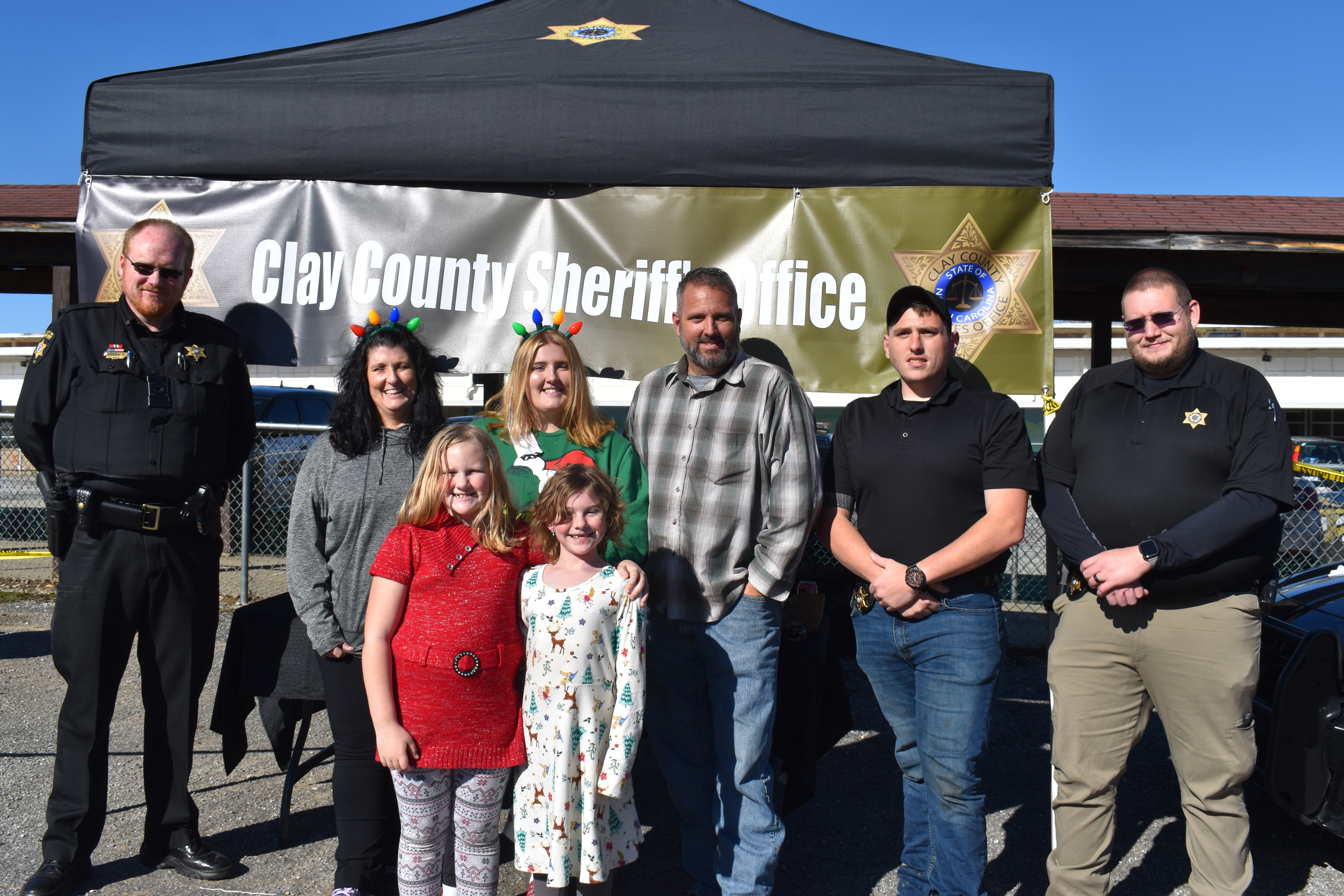 Becky Long • Clay County Progress Clay County Sheriff’s Office workers join the sheriff’s family members in manning the drive-thru station used for Saturday’s annual Sheriff’s Christmas Dinner. Shown, from left, are Andy Andrews, April Deese, Emma Deese, Sheriff Bobby Deese, Bryan Forsyth and Steven Evans. The two young volunteers in front are Brooklyn Woodard, 9, and Bailee Woodard, who will turn 7 in January, The girls helped serve during last years’s dinner. When asked why she liked to help, Brooklyn sai