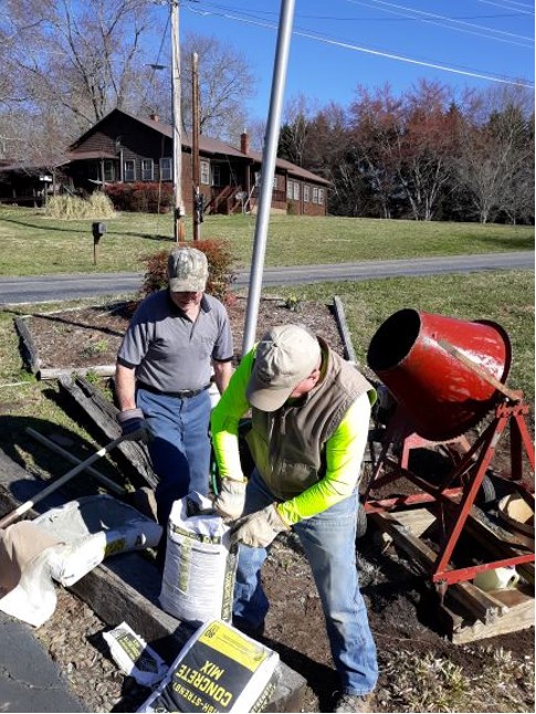 From left, Dwight McClure and Mitchell Shields mixes cement.