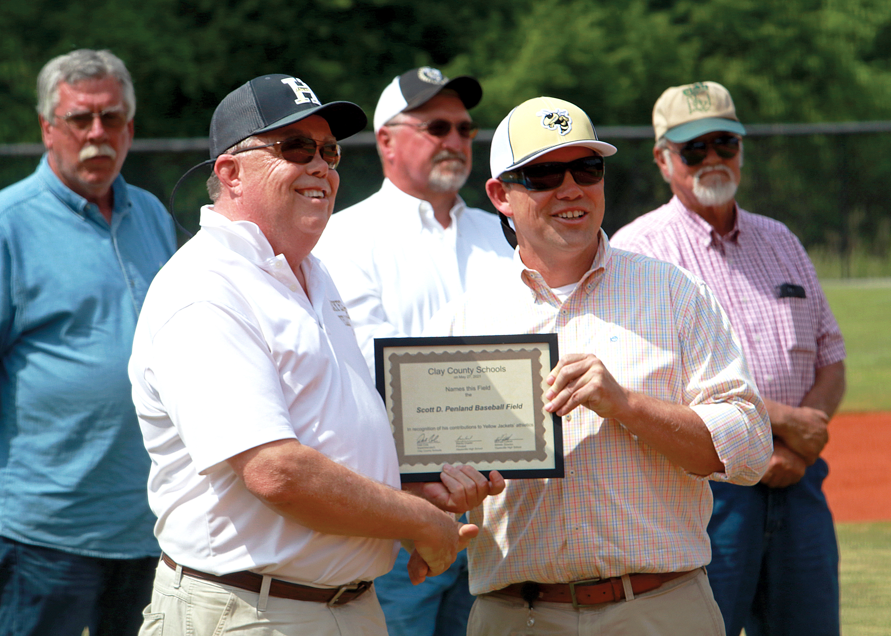 (Photo by Jared Putnam * Clay County Progress) Clay County Commissioner Scotty Penland, left, receives a certificate from Clay County School Superintendent Dale Cole. The new Hayesville High School baseball field was named Scott D. Penland Baseball Field in honor of the former superintendent.