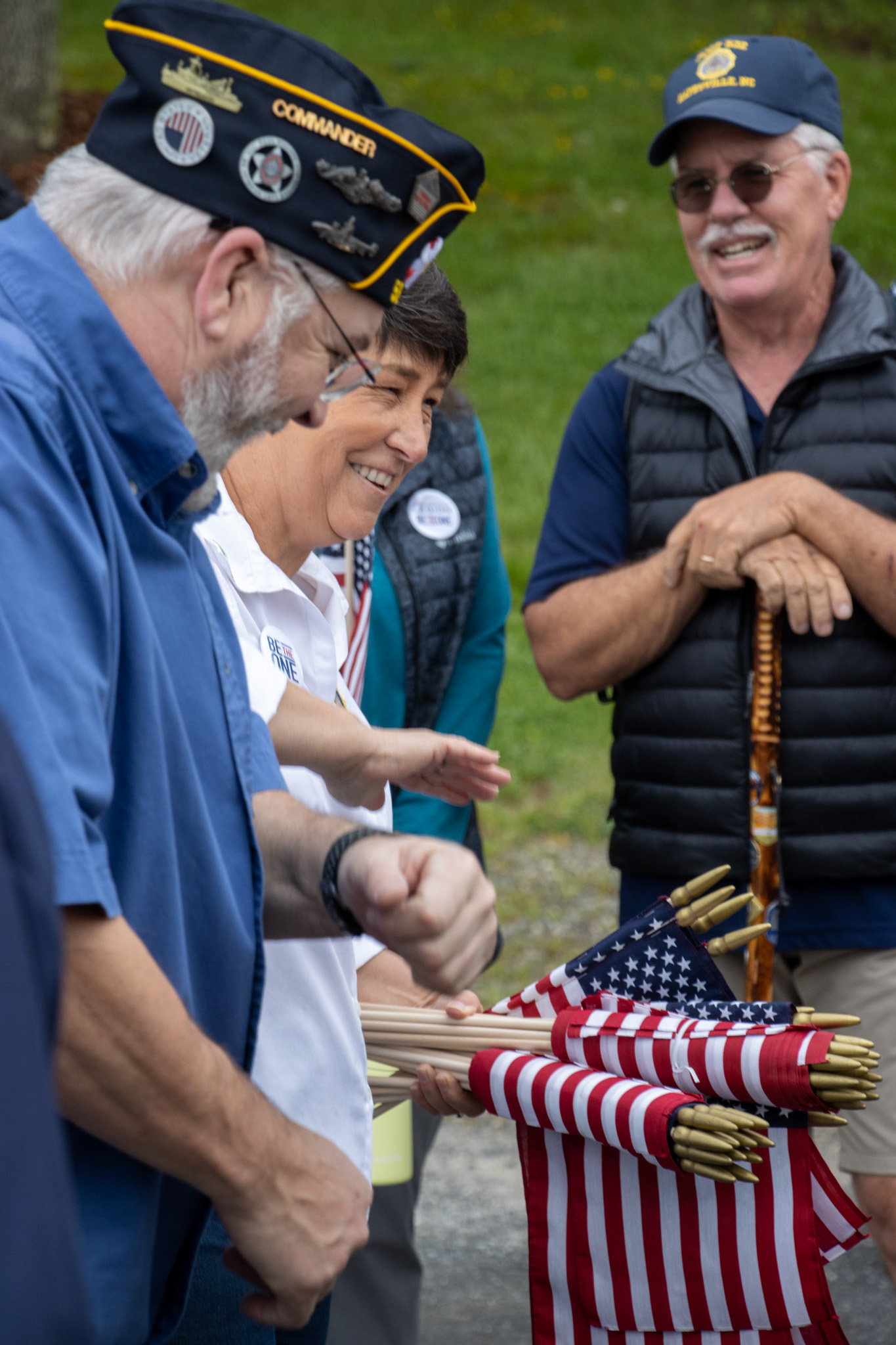 7ven-Feathers Photography American Legion Commander Robert Seibert and Suicide Prevention event coordinator Michelle Stegner hand out flags for participants to carry prior to the 2.2 mile walk.