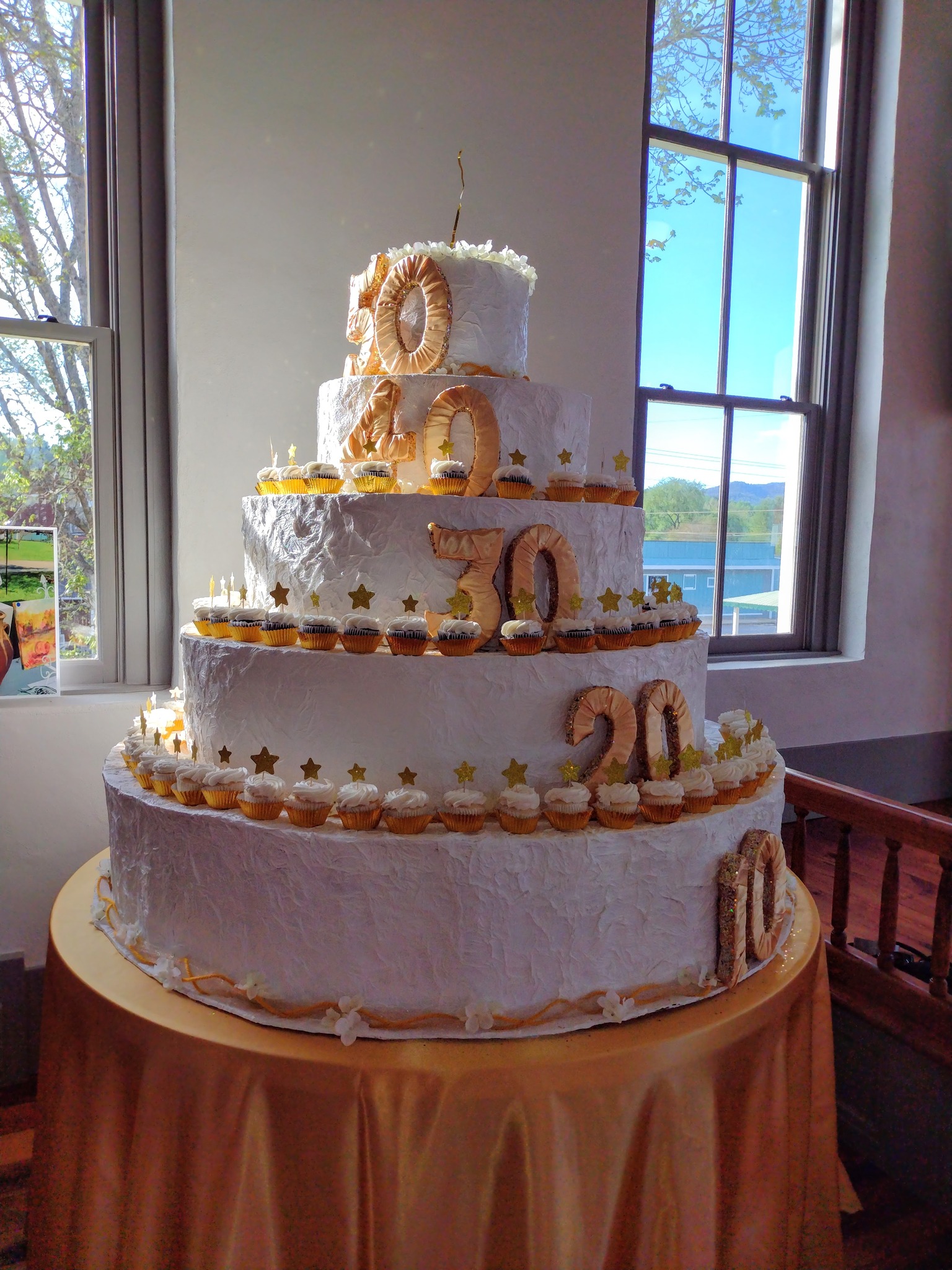 Photo by Tess Thomas A paper cake about six feet tall, was constructed of paper products and adorned with numbers representing the decades.