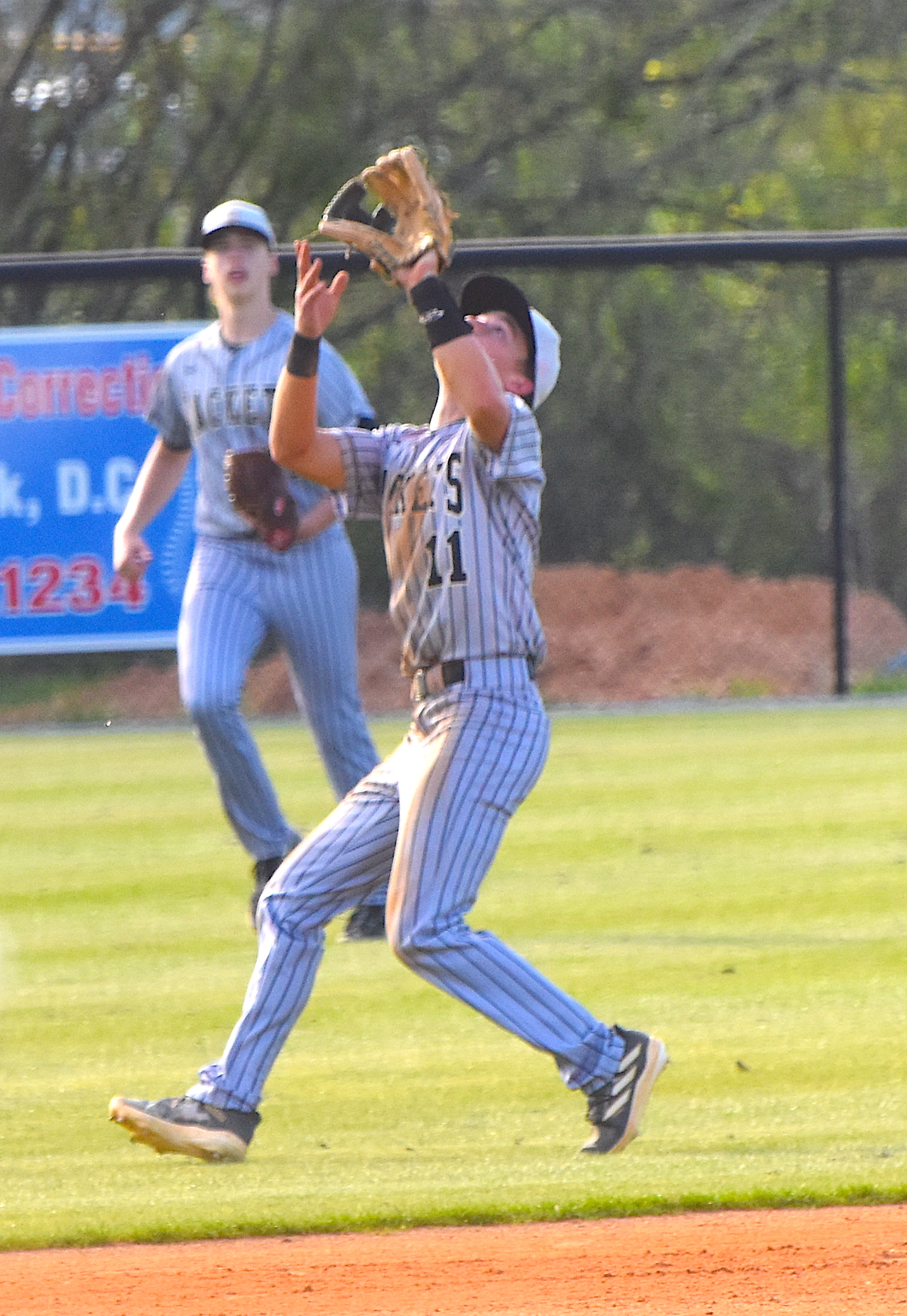 Gary Corsair • Clay County Progress Hayesville shortstop Tate Roberts, No. 11, camps under a pop fly during Monday's game against Towns County as left field Cade Caruso, No. 7, rushes toward the infield.