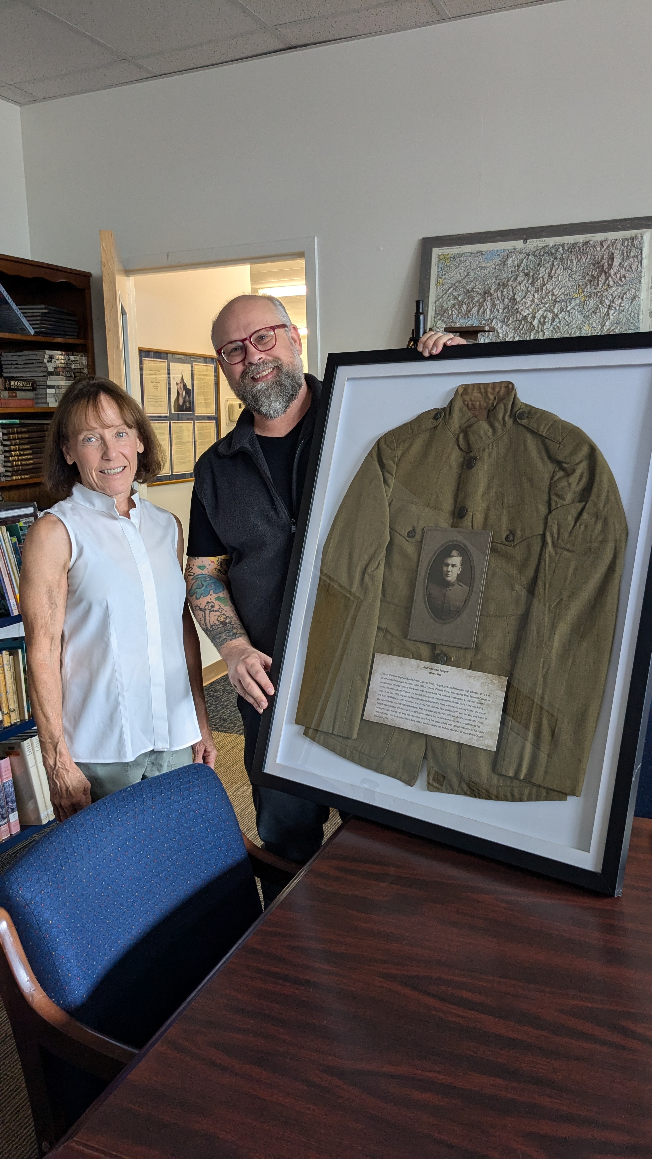 Branch manager and head librarian Griffin Anderson accepts Joanna Padgett-Atkisson donation of her grandfather Andrew Festus Padgett’s WWI Army jacket to Moss Memorial Library.