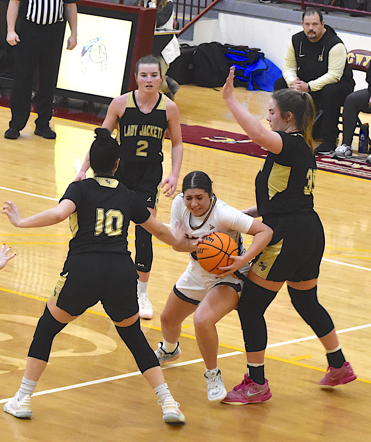 Gary Corsair • Clay County Progress A Lady Brave fights through a Hayesville triple team thrown at her by Lady Jackets Ava Shook, No. 2, Bryleigh Krieger, No. 10, and Mallory Peck as Hayesville Coach Chad McClure watches.