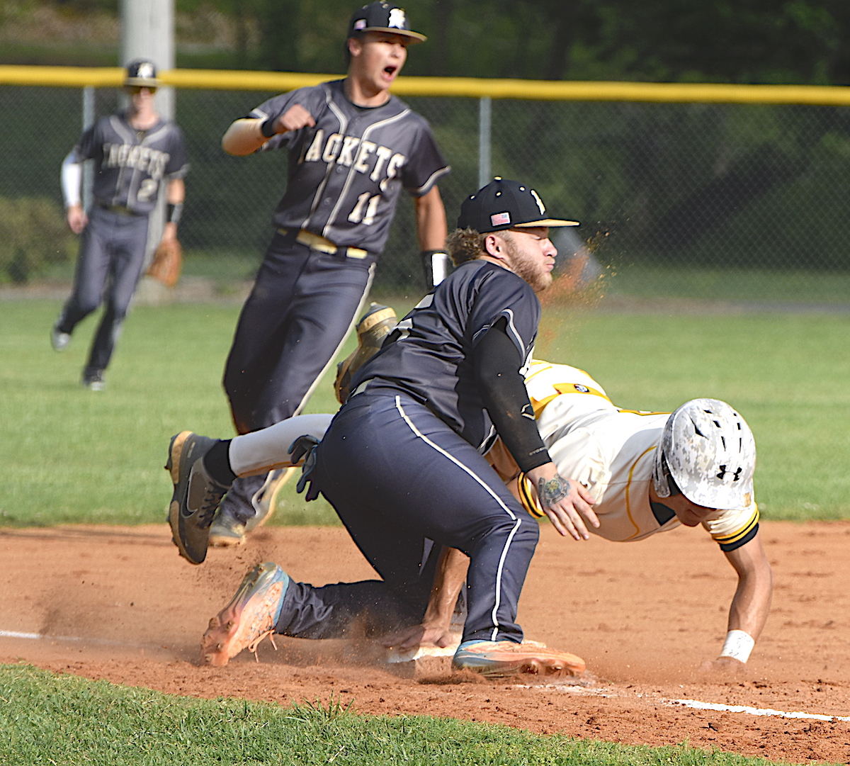 Gary Corsair • Clay County Progress Murphy base runner Adam Cook encounters the immovable object that is Hayesville third baseman Dawson Devane after Double D took a sizzling throw from Chance Hughes and tagged the Bulldog out. Hayesville shortstop Tate Roberts, No. 11, confirms the umpire's call.