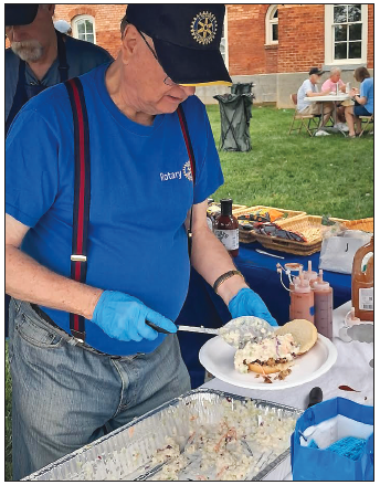 Becky Long • Clay County Progress Rotary volunteer Terry Parker tops off a barbecue sandwich with plenty of cole slaw at the food tent where business was steady throughout the four-hour event.