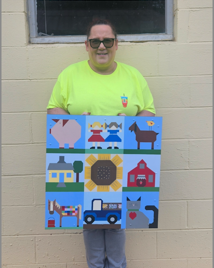 Michell Updyke picked up her custom barn quilt designed as a tribute to animals from her former rescue farm. The design is featured at her nutrition store in Franklin.