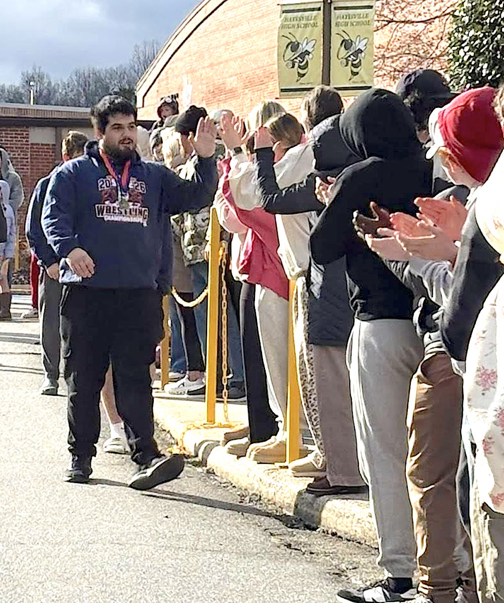 Photo provided by Hayesville High School Hayesville's first wrestling State Champion Rayland Martinez greets supporters who gathered along Yellow Jacket Drive to celebrate his gold medal in the 285 pound class.