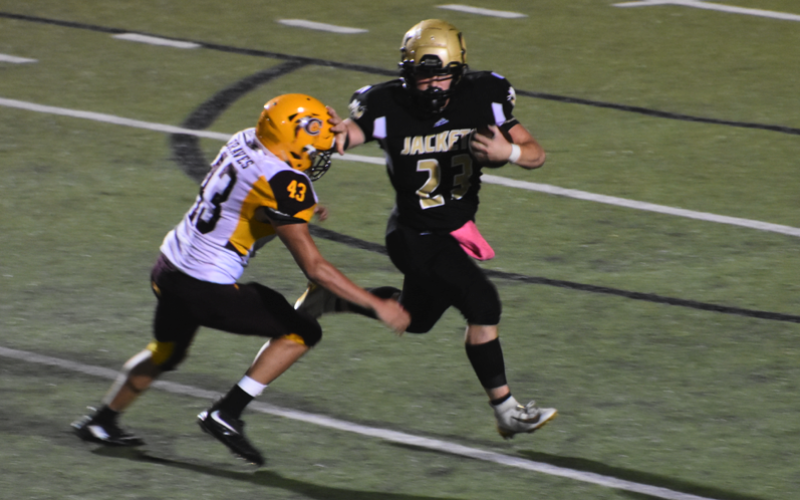 (Progress photo by Travis Dockery) Junior running back Blake McClure throws a stiff arm in the first steps of an 80-yard run.