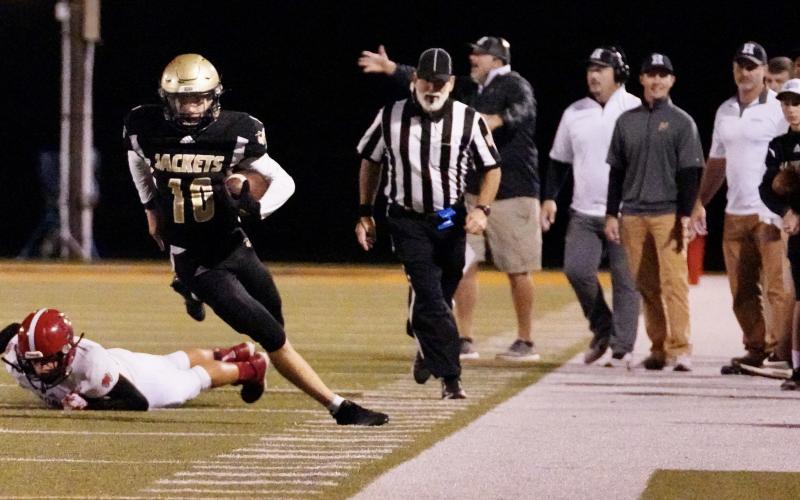 (Kelli Graves • Clay County Progress) Quarterback Hayden McClure is careful to stay inbounds during a run.