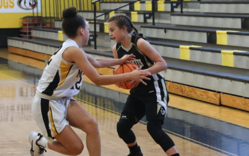 (Kelli Graves * Clay County Progress) Lila Roberts comes under attack as she tries to move the ball down the court.