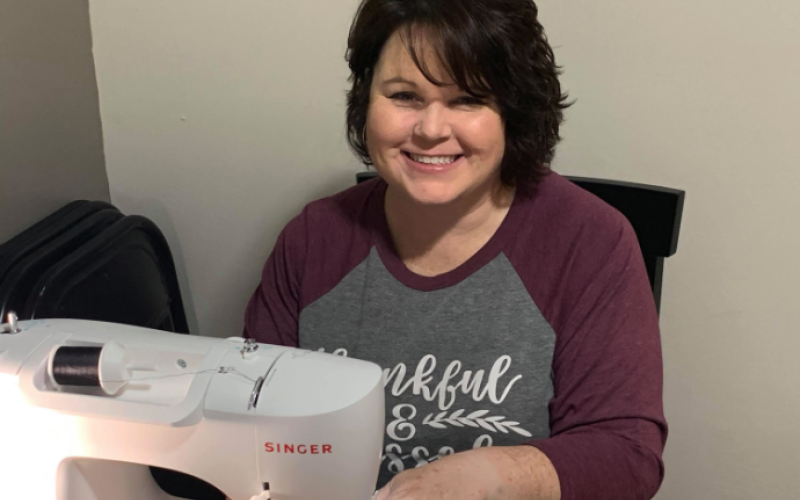 Jennifer Carter sits at her newly acquired sewing machine making masks to distribute to the community.