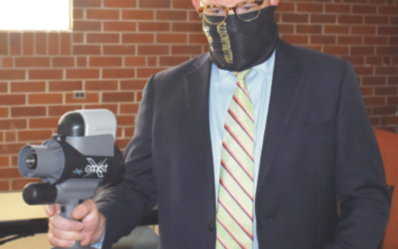 (Travis Dockery • Clay County Progress) Superintendent Dole Cole demonstrates how custodians will use the mister to make sure every inch of a room is protected.