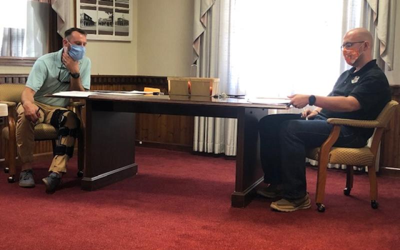 Lorrie Ross• Clay County Progress Two of Hayesville's council members look over the financial report at the August 10 meeting. Will Penland is on left with Austin Hedden on right.