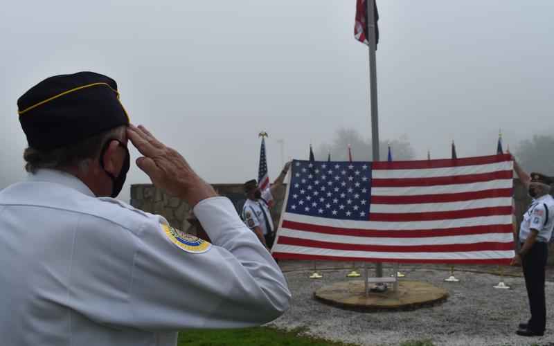 (Becky Long • Clay County Progress) George Lee American Legion 532 Commander Joe Buckner salutes as Dwight McClure and Phil Cantley conduct the folding of the American flag. The Legion hosted a 9/11 memorial service at the Veterans Memorial Park Friday morning.