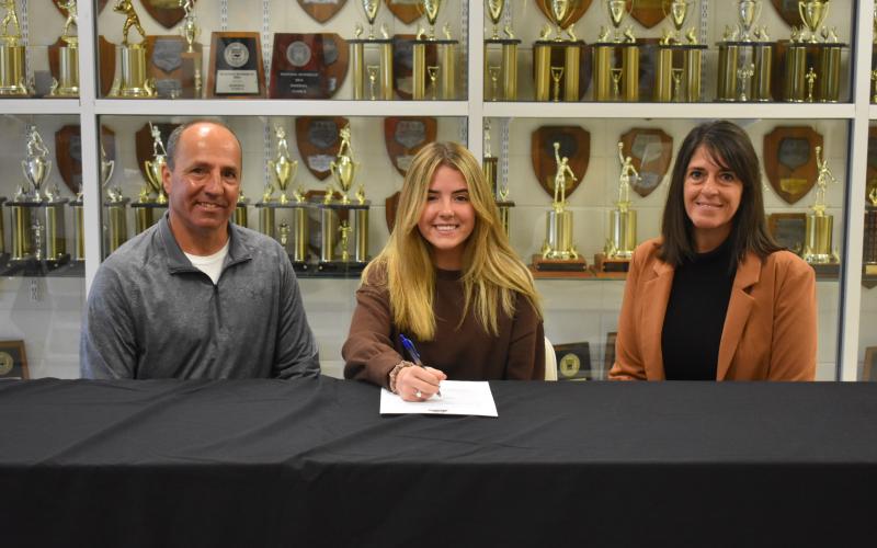 (Photo by Travis Dockery/ Clay County Progress) Jala Stamey, flanked by father Jeff and mother Jill, prepares to sign to play golf for Truett- McConnell University.