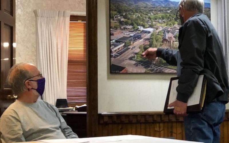 (Lorrie Ross • Clay County Progress) CCCRA representative Paul Price points to the aerial photo of Hayesville to show where the organization wants to place a new sign for the Beal Center.