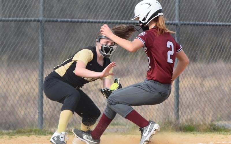 (Travis Dockery • Clay County Progress) Breanna Abrams tries to apply the tag to a runner on third.  The runner was called safe.