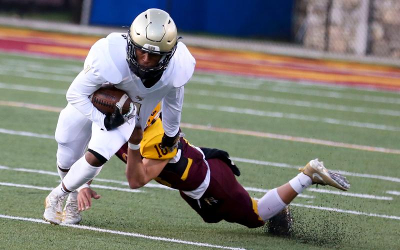 (Scot McKie • Cherokee One One Feather) Freshman Asher Brown tries to pull free from a diving would-be tackler.