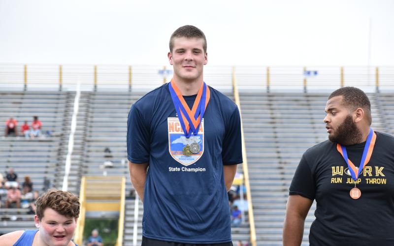 (Kevin Hensley • Graham Star) Jake McTaggart stands atop the podium with his gold medal for discus and silver medal for shot put.