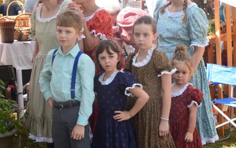(Progress photo by Lorrie Ross)  Cloggers are a favorite for festival attendees. They will  take the gazebo stage at 10am Saturday morning. Cloggers from the John C. Campbell Folk School in Brasstown range in age from three years to 80 years old. For Festival 2019, some of the youngest dancers waited to take the stage, but also the hearts of those watching. L-R: Benjamin Davis, 8; Romaine Davis, 6; Jones Ference, 7; and three year old Ella Ference.