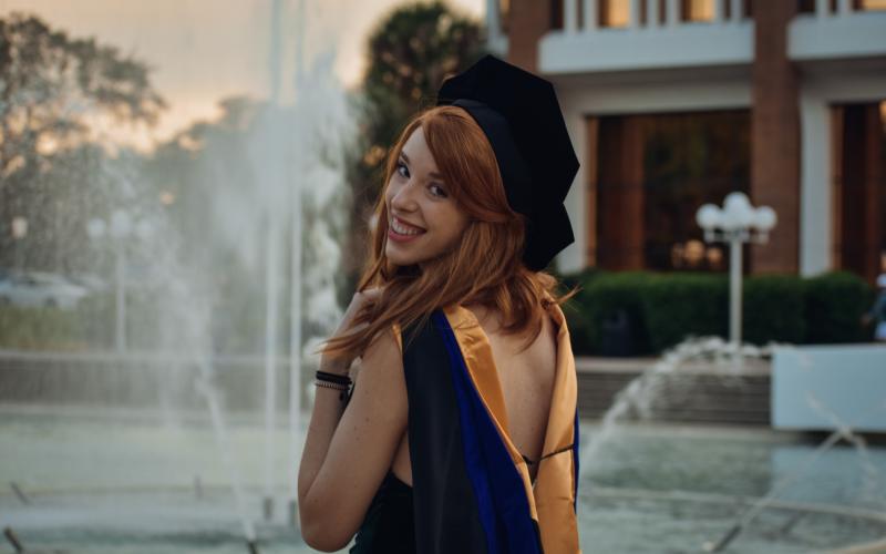 Hayesville High alum Dr. Brooke Baumgarten stops at the University of Central Florida reflection pond the day she received her PHd. She will be starting  postdoctoral research work at Los Alamos National Lab in March.