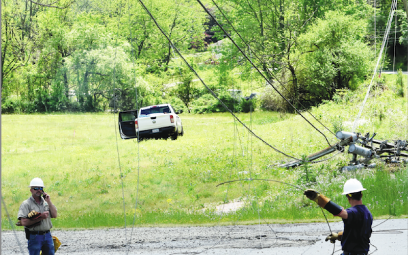 Becky Long • Clay County Progress Blue Ridge Mountain EMC workers survey the damages after a pickup truck struck a three-phase power pole on Myers Chapel Road Tuesday afternoon. The truck can be seen to the left of the damaged pole.