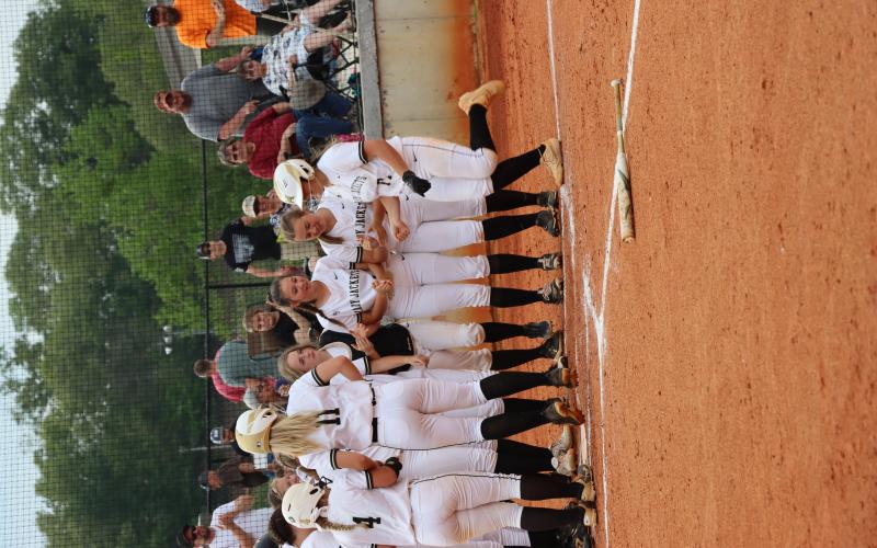 Lady Jackets celebrate after Gracelynn Anderson No. 17 slams a home run over the fence bringing in fellow runner Faith Odell No. 4.