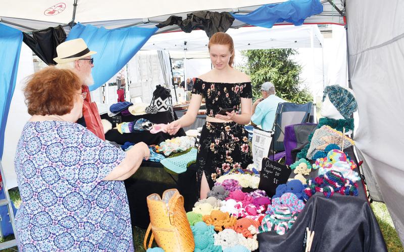 Brianna Ross enjoys chatting with customers during the Festival on the Square. Ross is owner of Boutique By Brianna. “It was great to see people get so excited about the products I put so much time and care into,” Ross said. “My stuffed bumblebees and octopuses were by far the best sellers this year, especially among kids and teens”