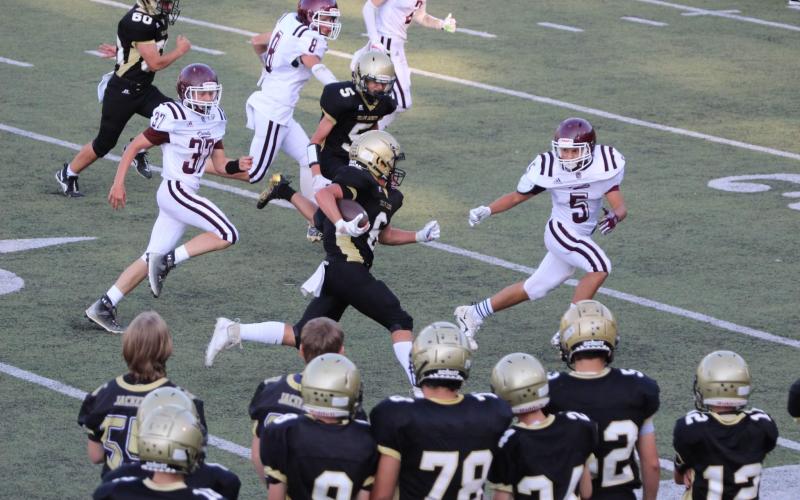 Photo by Kendra Coker JV Jacket Tre Graves runs through a tight defense for a first down.