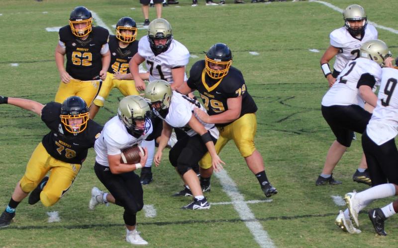 Photo • Kendra Coker Tre Graves gains yardage among a pack of Bulldogs thanks to solid back-up.