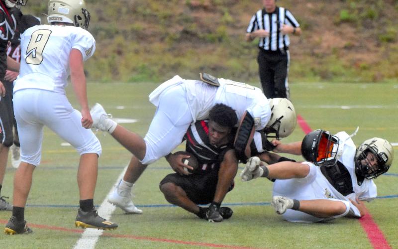 Gary Corsair • Clay County Progress North Georgia's quarterback loses his helmet during a bone crushing tackle by Yellow Jackets Jeremy Graves, No. 51, and Cameron Payne as teammate Seth Leek, No. 9, looks on.