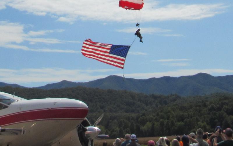 Photo by Linda Hagberg MSG Robert Scott displays the American flag on his way down from 10,000 feet and lands on the airport runway.