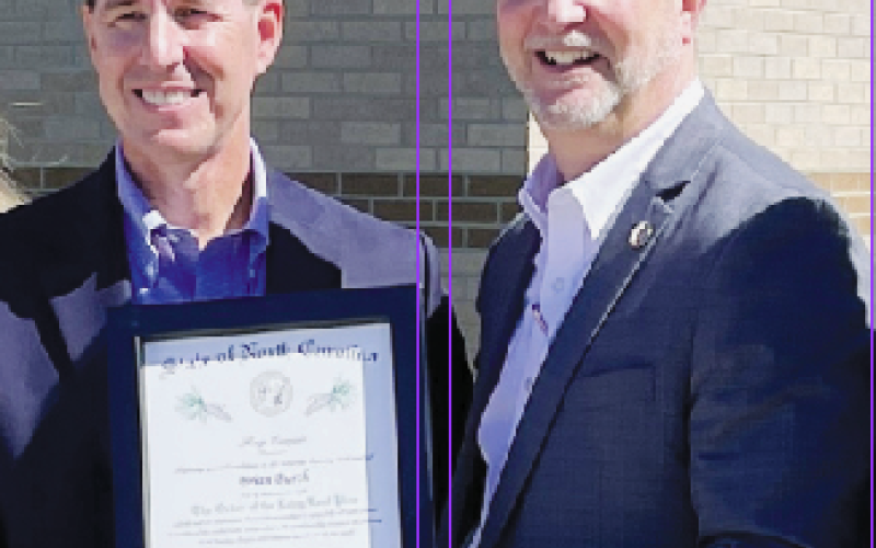 Kevin Hensley • Graham Star Retired Department of Transportation engineer Brian Burch receives a certificate marking his membership in the Order of the Long Leaf Pine by N.C. Department of Transportation Secretary Eric Boyette, following a highway project groundbreaking ceremony at Robbinsville High School on Monday. The Order of the Long Leaf Pine is among the most prestigious awards presented by the governor of North Carolina.