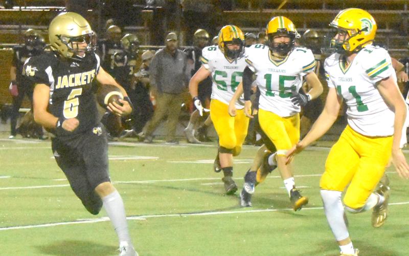 Gary Corsair • Clay County Progress  Logan Caldwell angles away from a trio of Trojan defenders.