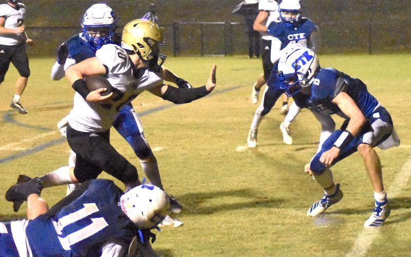 Gary Corsair • Clay County Progress Taylor McClure, No. 20, straight arms Christ The King's Jake Dulski as TMac sidesteps two opponents.