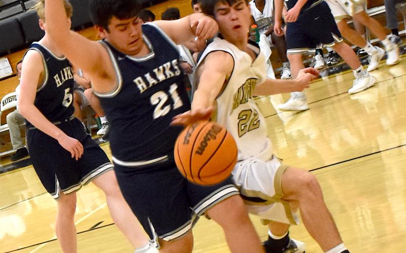 Hayesville's Jakob McClure, No. 22, fights for a loose ball during the Yellow Jackets' 72-14 victory over Nantahala.