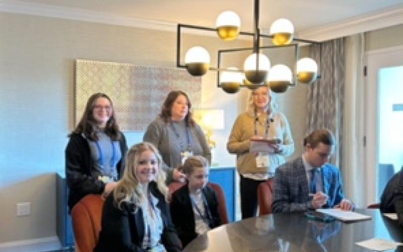 Photo Submitted HHS students Lyndsey Evans, seated on left, and Maya Polk, standing behind her, chat with N.C. Congressman Chuck Edwards’ staff. Others at the table include CADCA attendees from Haywood County.