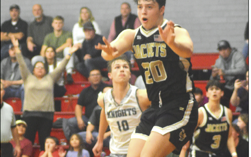 Gary Corsair • Clay County Progress Hayesville’s Taylor McClure, No. 20, dumps a pass to Logan Caldwell after splitting the Robbinsville defense Monday night in the conference tournament in Andrews.