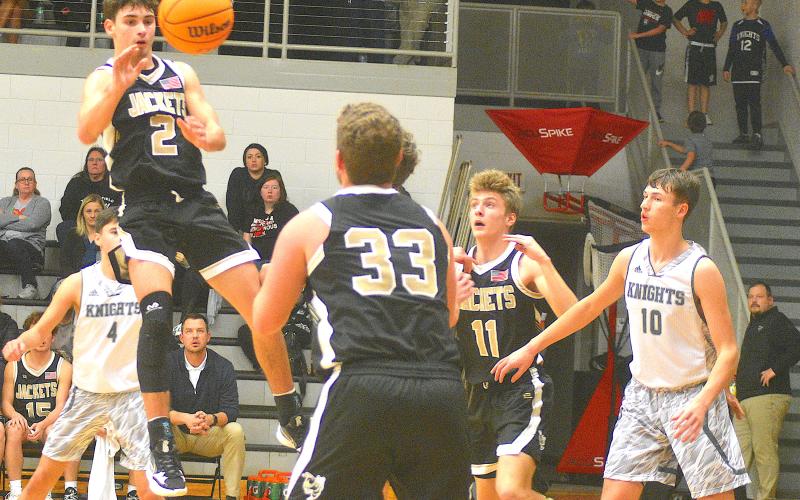 Gary Corsair • Clay County Progress Hayesville's Logan Caldwell, No. 2, splits the Robbinsville defense and dishes to Kyle Lunsford, No. 33, as Isaac Chandler, No. 11, boxes out.
