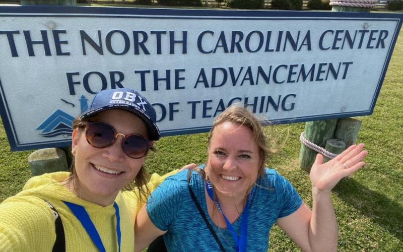 Ginger Scerri and teacher Barbara Rodriguez pose by the sign for North Carolina Center for the Advancement of Teaching in Ocracoke, N.C. Scerri spent most of the week with 23 other teachers from around the state to share and learn from each other.